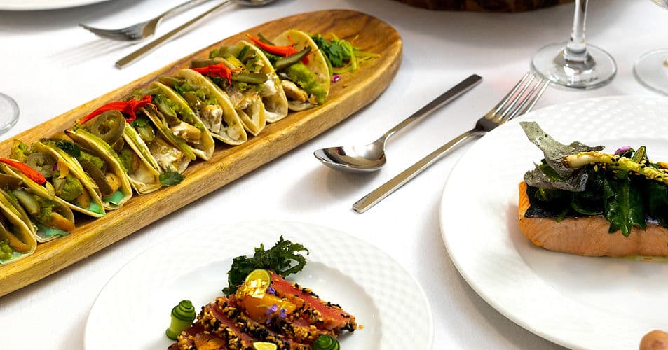 Elegantly plated dishes on a table with warm lighting